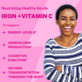 An image of a smiling woman with her arms crossed. Nourishing healthy bonds. Iron + Vitamin C to support: energy levels, hemoglobin production, cognitive function, oxygen transportation through the body.