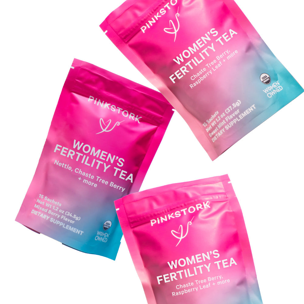 Pink Stork Women’s Fertility Tea pouches in vibrant pink and blue packaging, featuring herbal ingredients like nettle, chaste tree berry, and raspberry leaf.