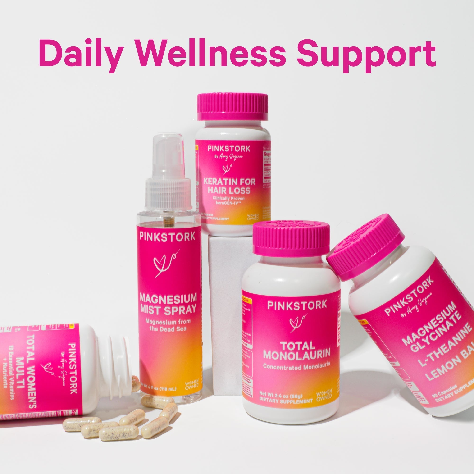 Pink Stork daily wellness supplements including Magnesium Mist Spray, Keratin for Hair Loss, Total Monolaurin, Magnesium Glycinate with Lemon Balm, and Total Women’s multivitamin capsules.