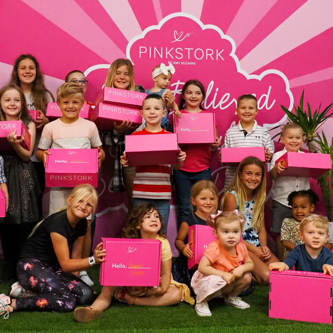 Kids holding Pink Stork boxes