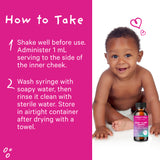 African American baby smiling and sitting behind a bottle of Pink Stork Baby Sleep Drops. Directions on how to take the product.