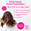 Pink Stork Detox Gummies. We put it to the test. cGMP + NSF certified facility. Based + blended in the USA. Unannounced sampling + testing. Cruelty free. Women facing away from the camera running her fingers through her brown hair.