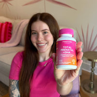Woman holding a Total Prenatal bottle