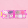 An Pink Stork pill case full of many different capsules and gummies. 