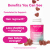 Bottle of Pink Stork Postpartum Hair Loss Gummies with gummies surrounding it and falling into it. Benefits your can see.