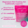 Bag of Pink Stork Postpartum Sitz Bath sitting in a pile of bath salts. Magnesium-rich soaking aid. Pure magnesium supports skin moisture and softening.