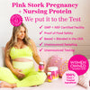A pregnant woman with one hand on her belly and the other holding a bottle of Pink Stork supplements. Pink Stork Pregnancy + Nursing Protein.