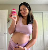 Pregnant woman holding a Total Prenatal bottle