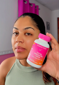 Woman holding a Total Prenatal bottle