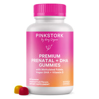 Pink Stork Premium Prenatal + DHA Gummies bottle with pink cap and two fruit-flavored gummies in front.