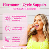 A blonde woman about to take a Pink Stork Capsule. Hormone + Cycle Support.