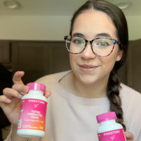 woman holding total prenatal bottles