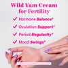 Hands spreading lotion on wrist. Wild Yam Cream for fertility.