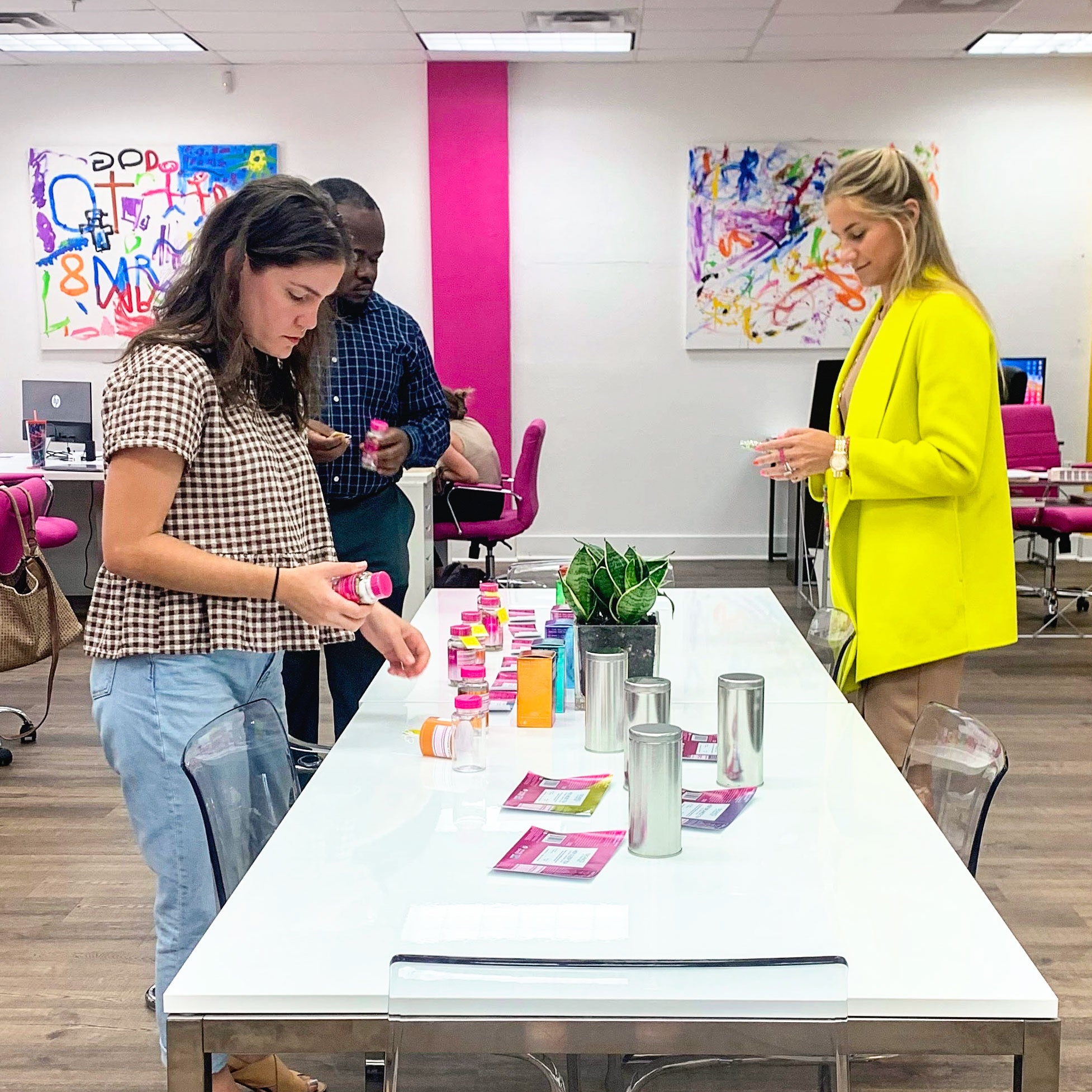 Amy and two employees in the Pink Stork office looking at packaging.